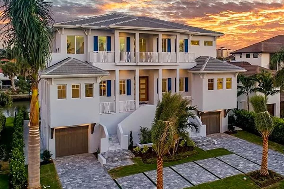 House plan exterior: Three-story modern house with balconies, white railings, blue shutters, and three garage bays.