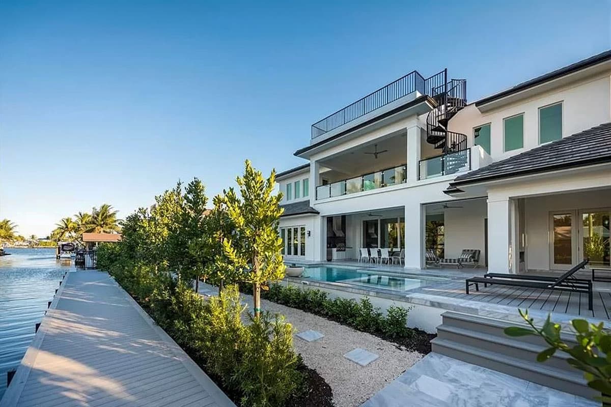 Modern house plan exterior with multiple balconies, a spiral staircase, and a pool.