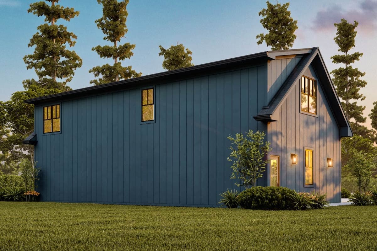 Modern blue house with a sloped roof. The house is surrounded by trees and a green lawn.