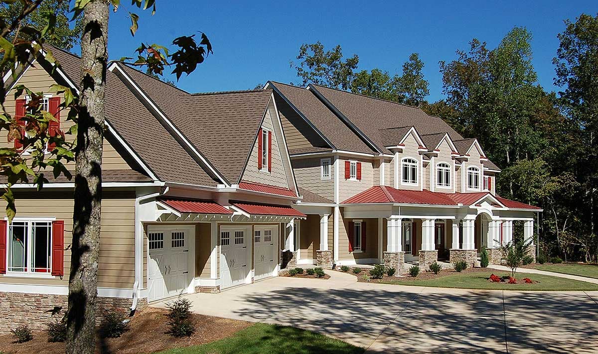 House plan exterior showing a two-story home with a front-facing three-car garage, covered porches, multiple gables, and dormers.