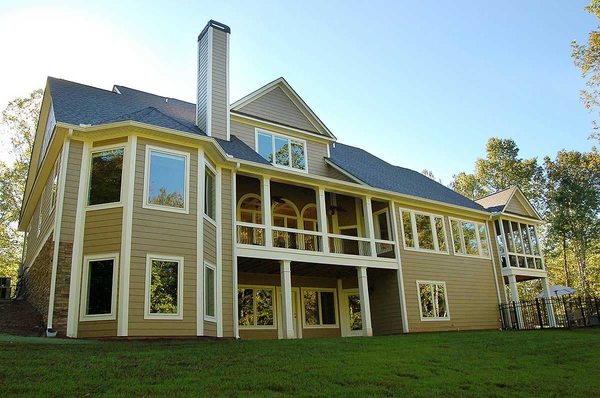 House plan exterior with multi-story design, bay windows, stone accents, covered balcony, and screened porch.