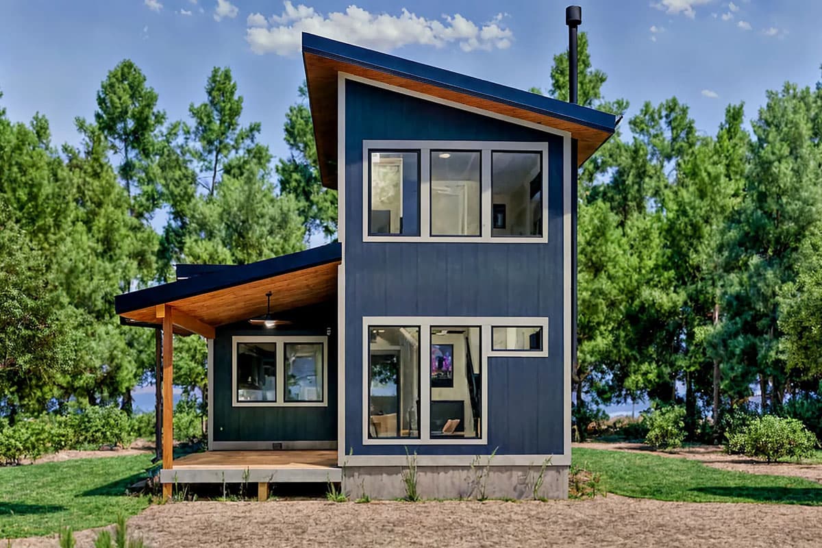 Modern house plan exterior with two stories, dark blue siding, asymmetric roofline, and covered porch.