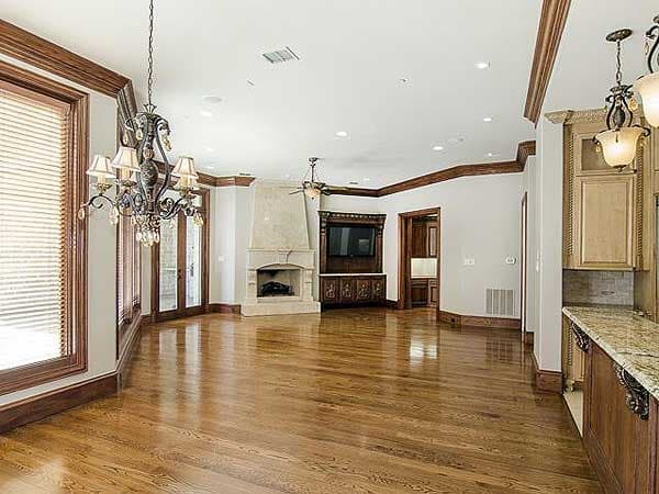 Living area with fireplace, built-in media center, hardwood floors, and kitchen island.