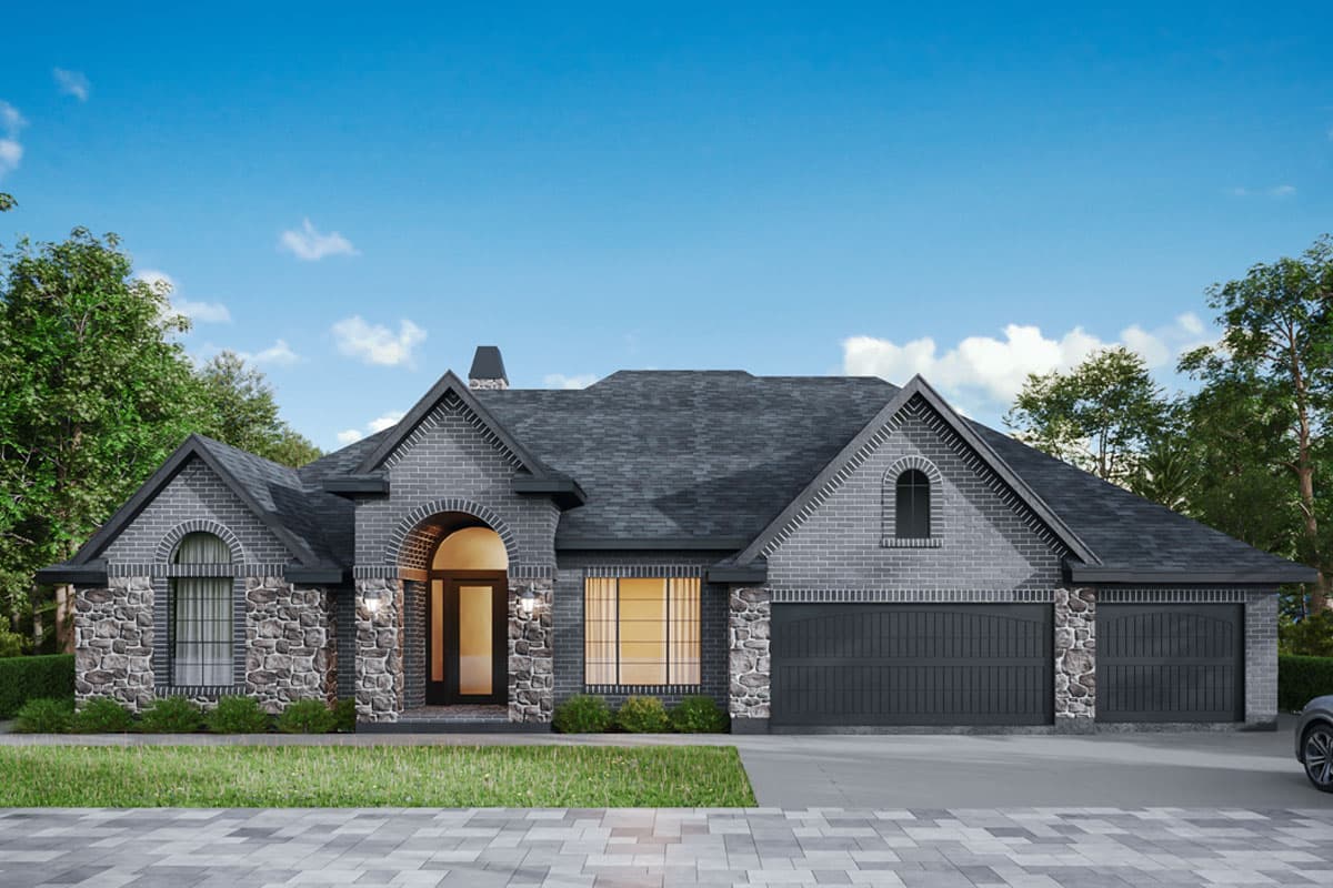 House plan exterior. Single-story design with brick facade, arched entryway, and multi-gable roofline. Stone accents and an attached two-car garage.