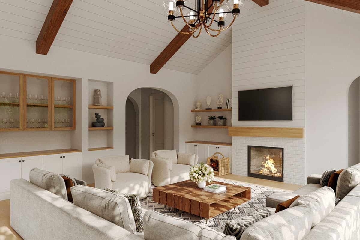 Living room with vaulted ceiling, exposed beams, shiplap fireplace, and built-in shelving.