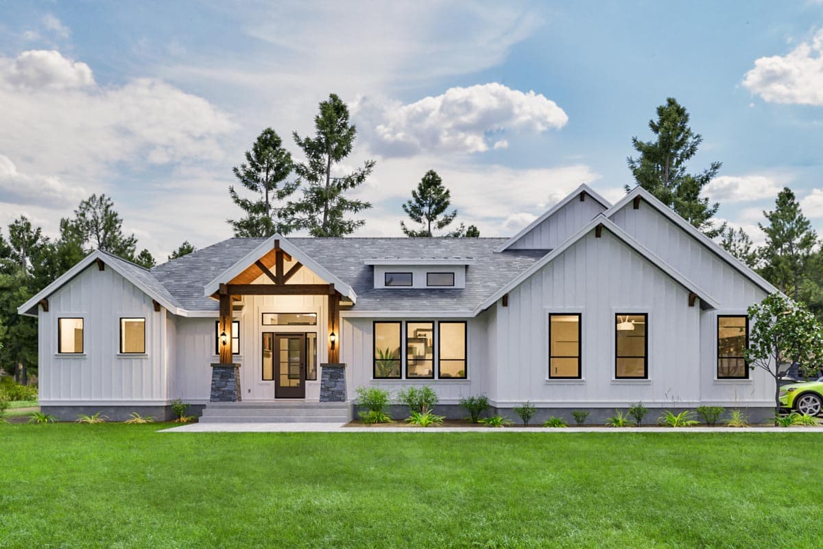 House plan exterior. Modern farmhouse style. Features include a covered porch, multiple gables, and a mix of large windows and dormers.