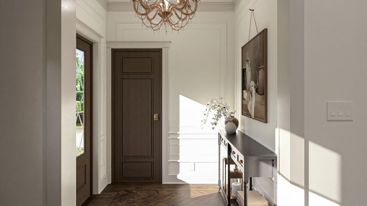Interior view of a hallway with paneled doors, decorative molding, a console table, and a chandelier.