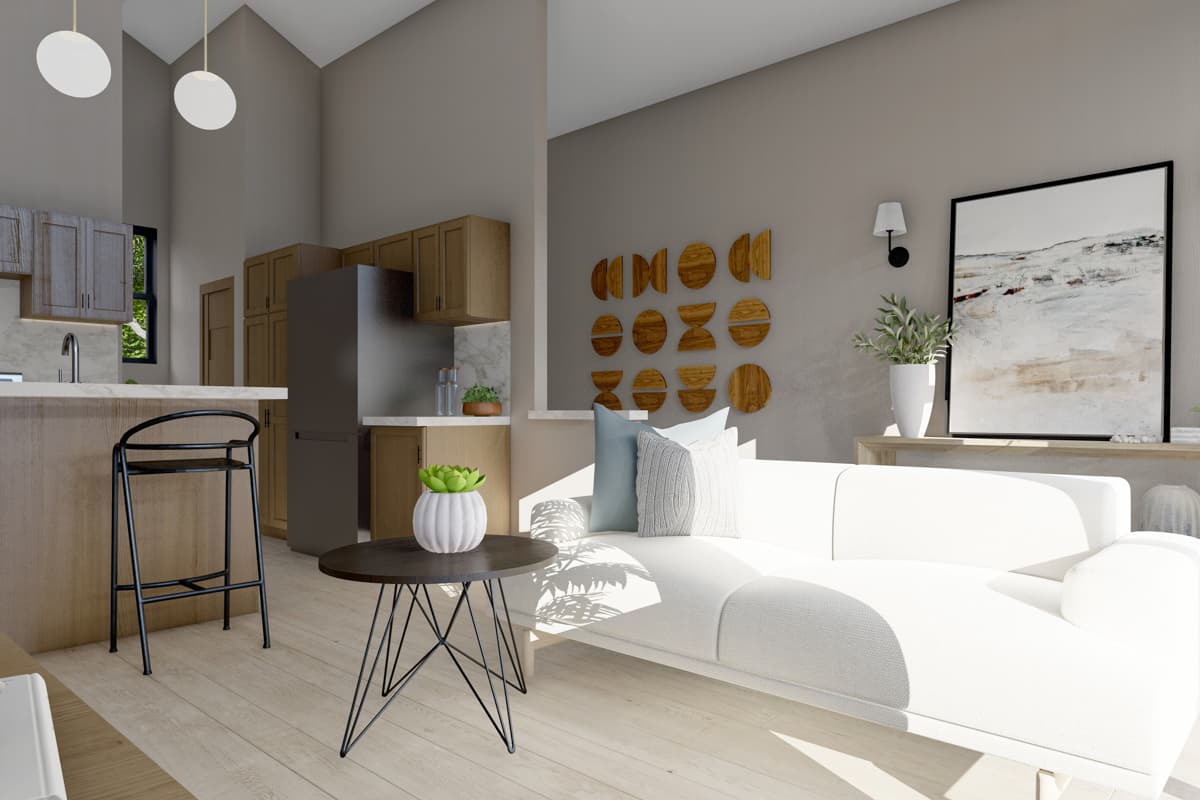 Open-concept living area with kitchen island, modern sofa, and vaulted ceiling.