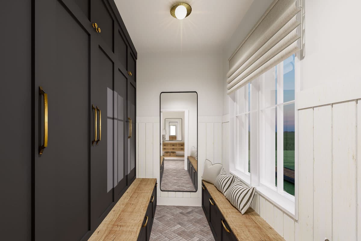 Entryway with dark paneled walls, wood benches, floor-to-ceiling mirror reflecting a hallway, and large windows with Roman shades.