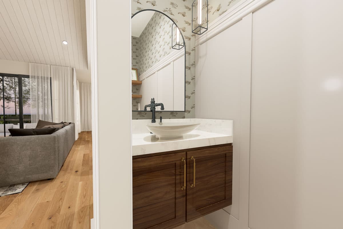 Powder room with dark wood vanity, vessel sink, arched mirror, and adjacent living area with sofa.