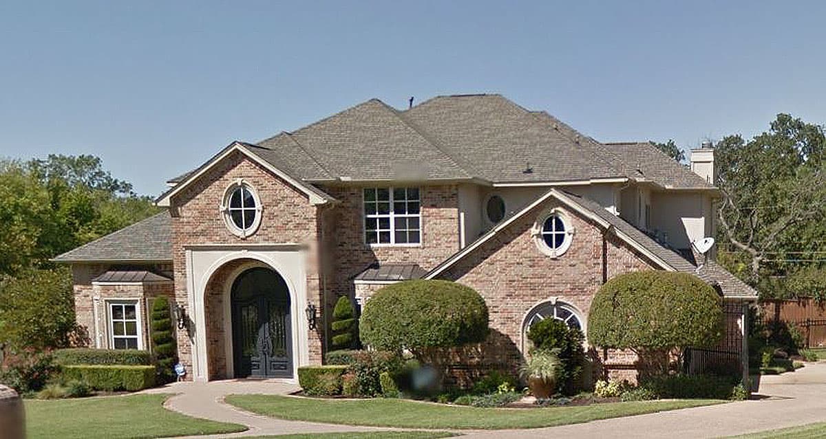 House plan exterior: Two-story brick home with arched entryway, gables, dormers, and multi-level rooflines.