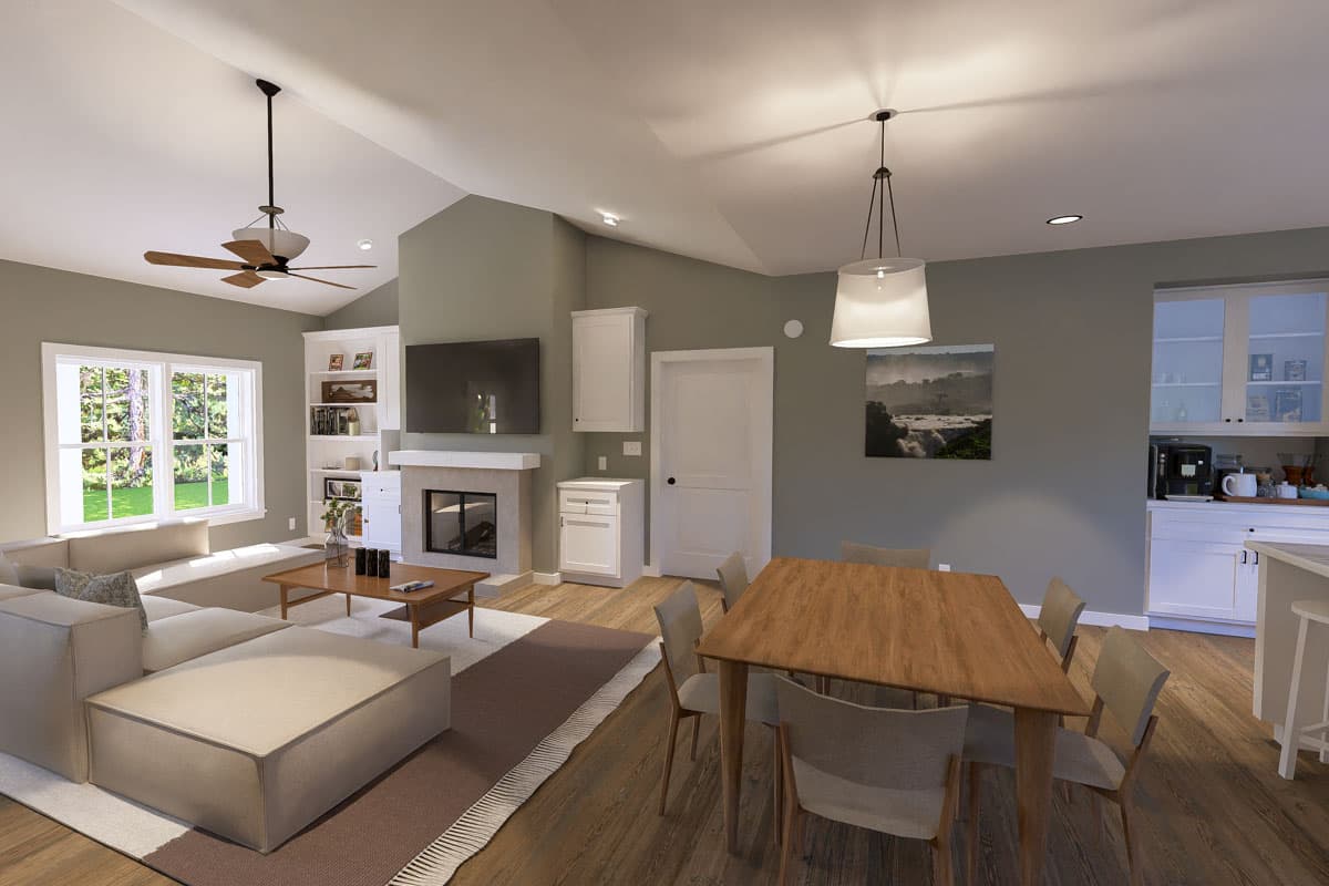 Open concept living, dining, and kitchen with fireplace, vaulted ceiling, and large windows.