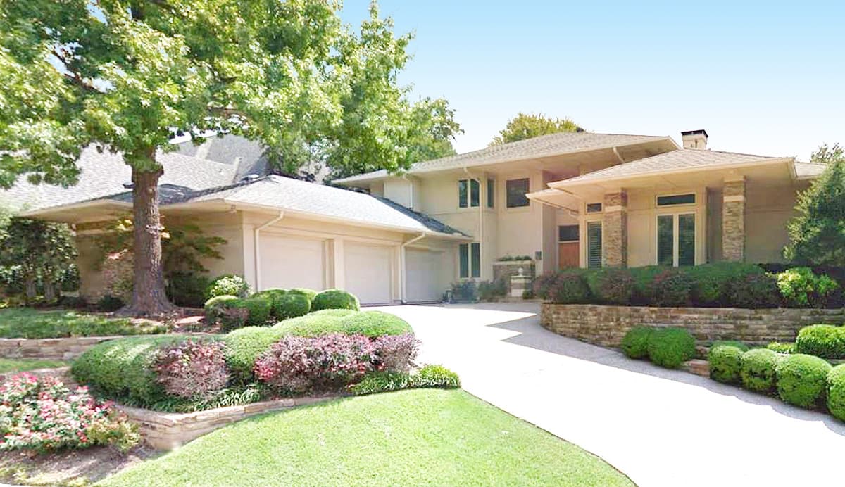 House plan exterior: two-story contemporary with attached three-car garage, flat rooflines, and stone accents on columns.
