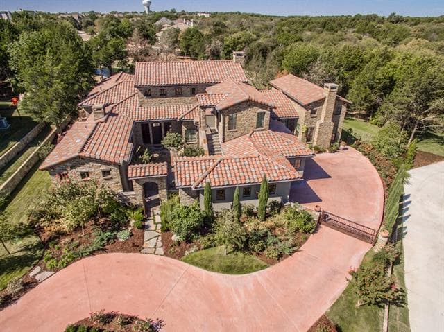 House plan exterior: Estate home with tile roof, stone exterior, multiple gables, and curved driveway.