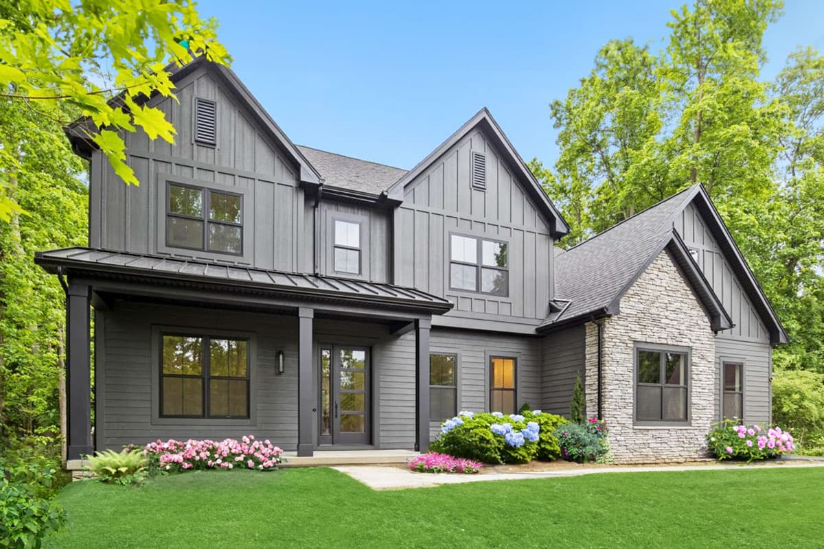 House plan exterior: Two-story modern farmhouse with board and batten siding, stone accent, metal roof porch, and multiple gables.