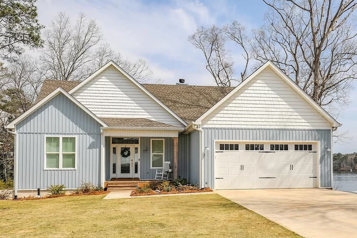 House plan exterior. Ranch style with a gabled roof, board and batten siding, shake siding, and a two-car garage.