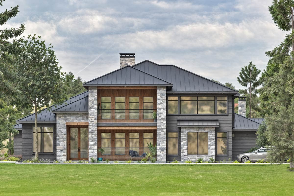 Two-story modern house plan exterior with stone and wood accents, standing seam metal roof, balcony, and large windows.