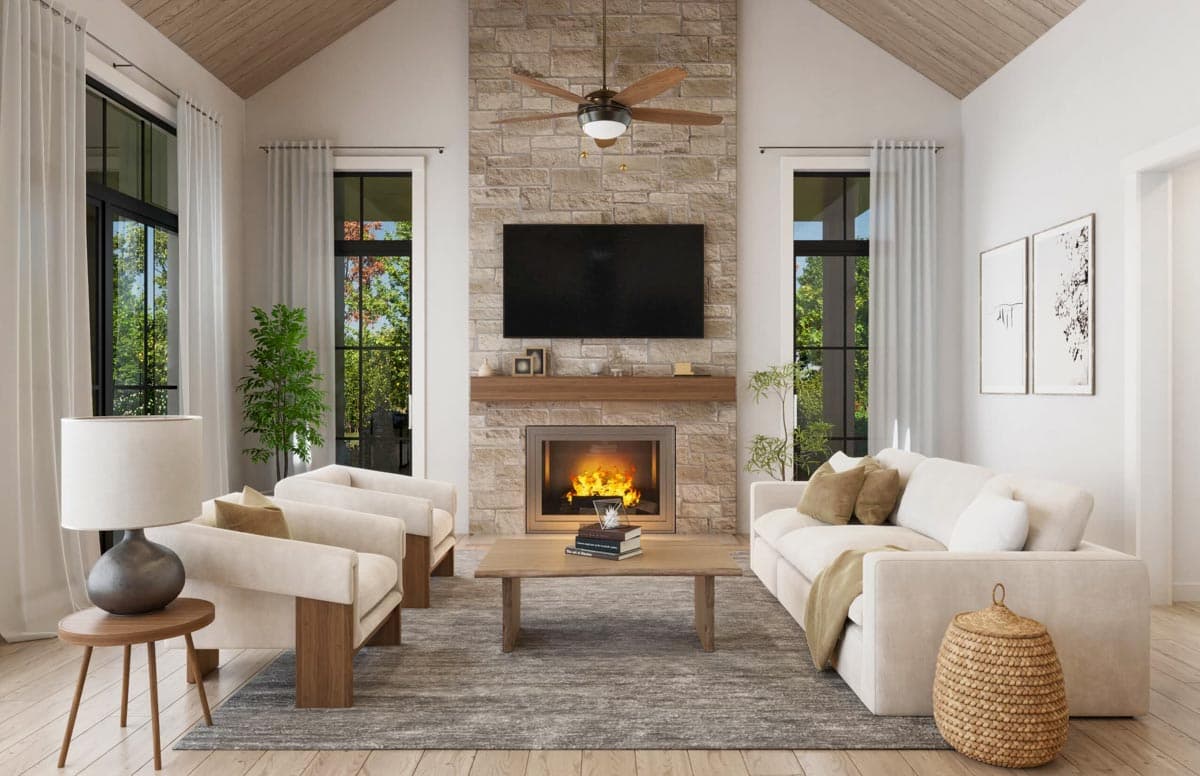 Living room with stone fireplace, vaulted wood-paneled ceiling, large windows, and comfortable seating.