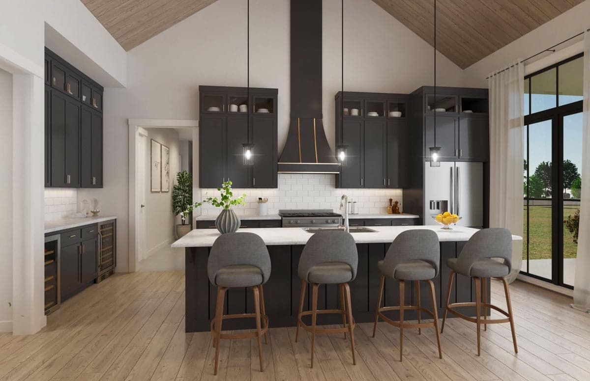 Kitchen with vaulted ceiling, dark cabinetry, island with seating, and large windows.