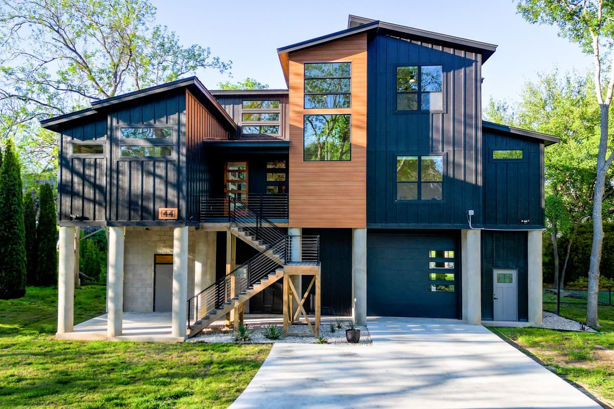 Modern house plan exterior. Two-story with board and batten siding, multiple gables, a covered entry and a detached garage.