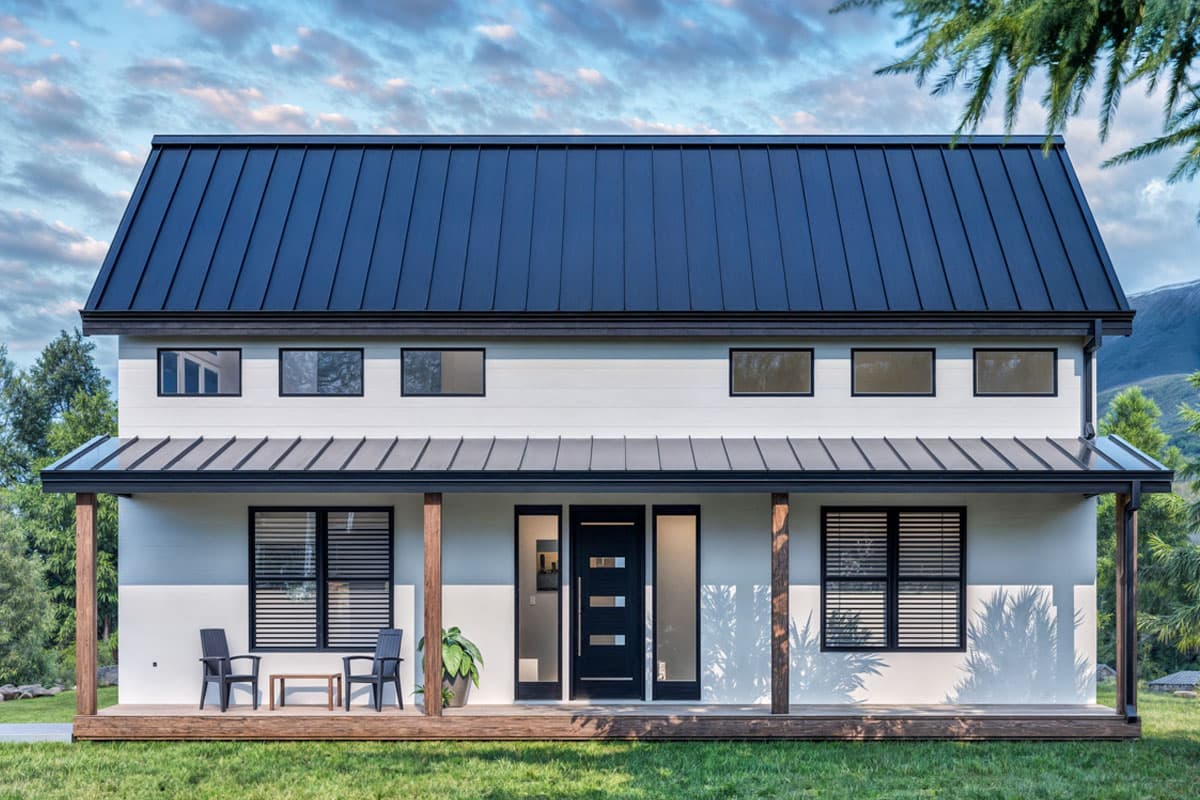 Two-story house plan exterior with a metal gable roof, wraparound porch, and horizontal siding.