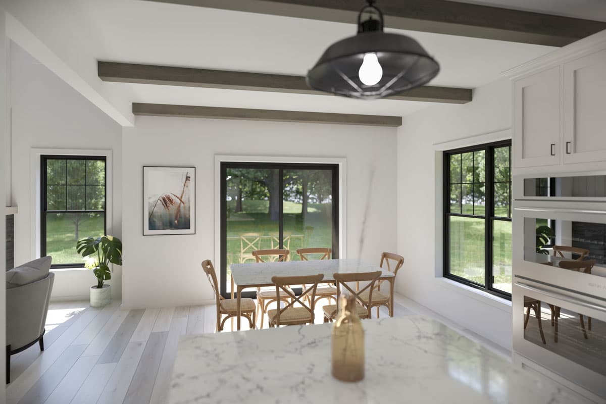 Interior view of a dining room.  Features a marble top table with wooden chairs, black windows and light-colored wood beams.