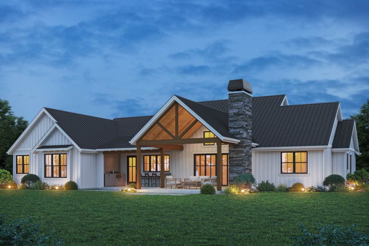 Modern Farmhouse house plan exterior with white board-and-batten siding, dark metal roof, stone chimney, and covered patio.
