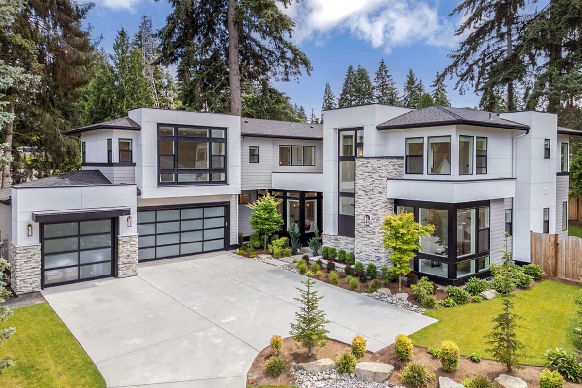 House plan exterior. Modern style, two-story home with flat rooflines, a two-car garage, and stone accent wall.