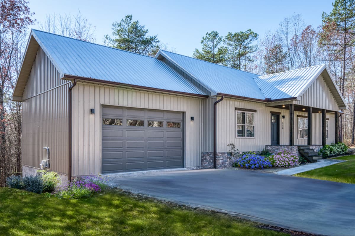 House plan exterior with a metal roof, vertical siding, attached garage, and covered front porch.