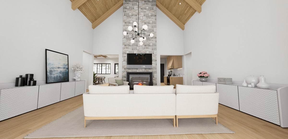 Living room with vaulted wood beam ceiling, stone fireplace, sectional sofa, and open view to dining area and kitchen.