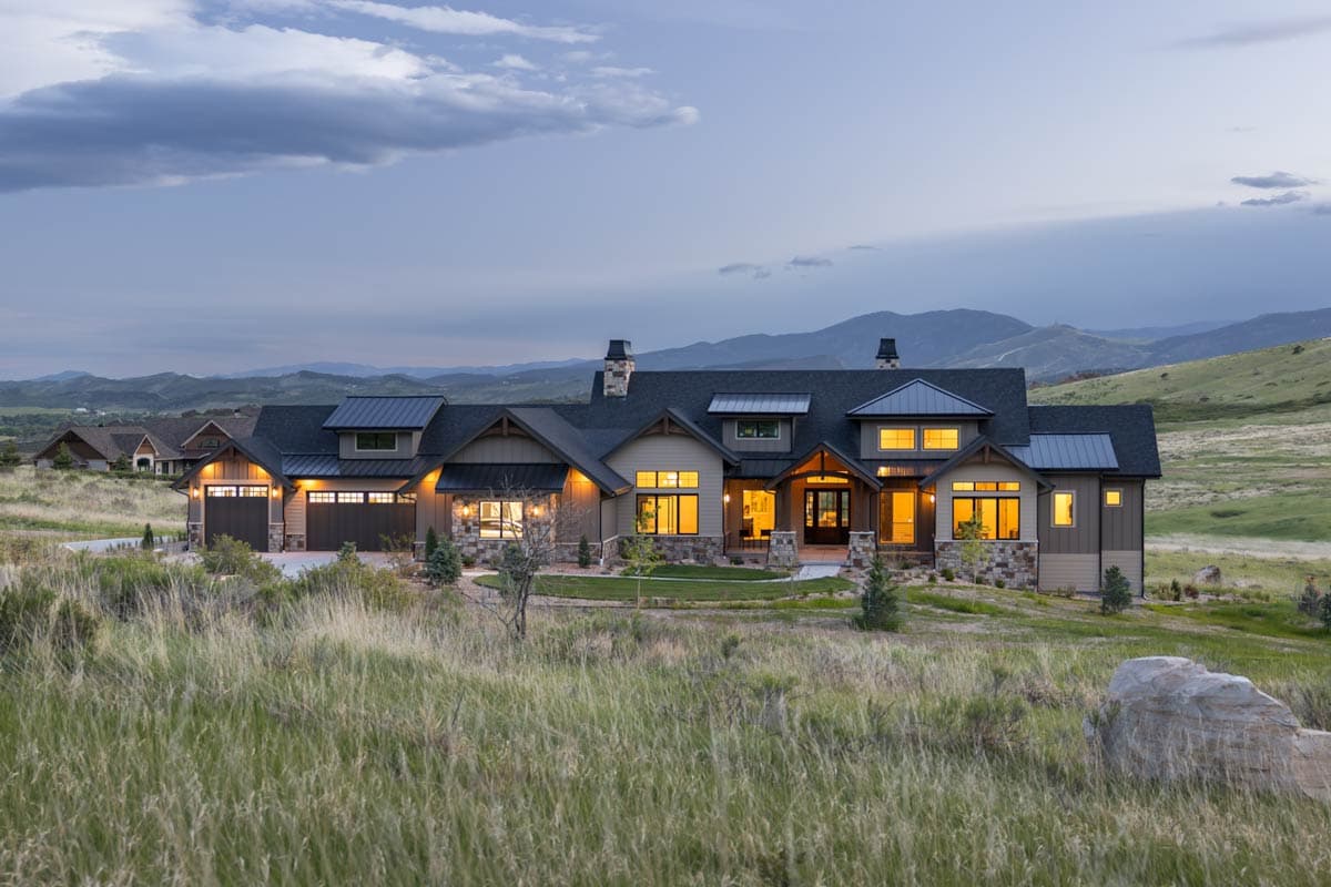 House plan exterior: Modern Farmhouse style, 1.5 stories, with a three-car garage, gable rooflines, and stone accents.