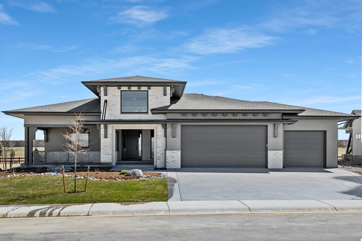 House plan exterior with two stories, modern design, a covered entry porch, multiple gables, and a three-car garage.