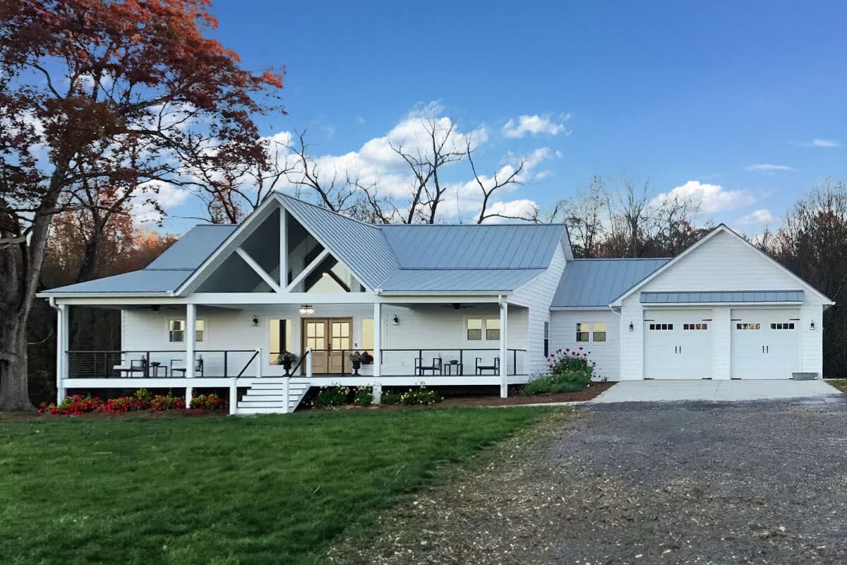 House plan exterior. Modern farmhouse style with gabled roof, covered porch, and attached two-car garage. Features a metal roof and large front-facing gable.