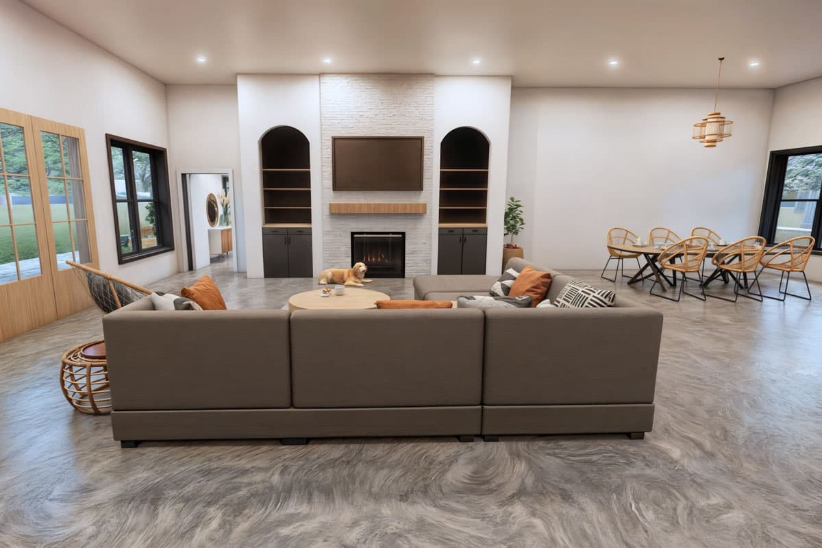 A modern living room featuring a large sectional sofa, fireplace, and a dining area. A dog rests by the fireplace, completing the cozy scene.
