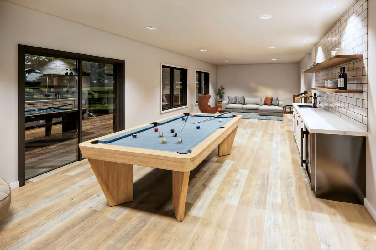 A modern game room featuring a pool table with balls arranged and cues ready. A wet bar, a sofa, and large glass doors complete the scene.