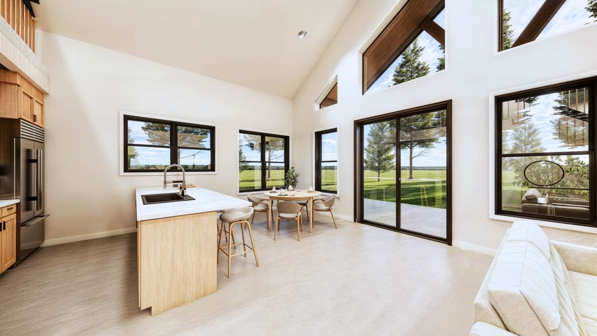Open concept living area with kitchen island, dining area, and vaulted ceiling with large windows.