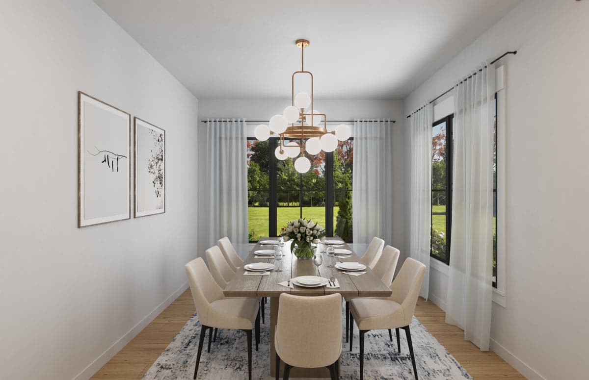 Dining room with large table set for ten, modern chandelier, artwork, and tall windows overlooking a yard.