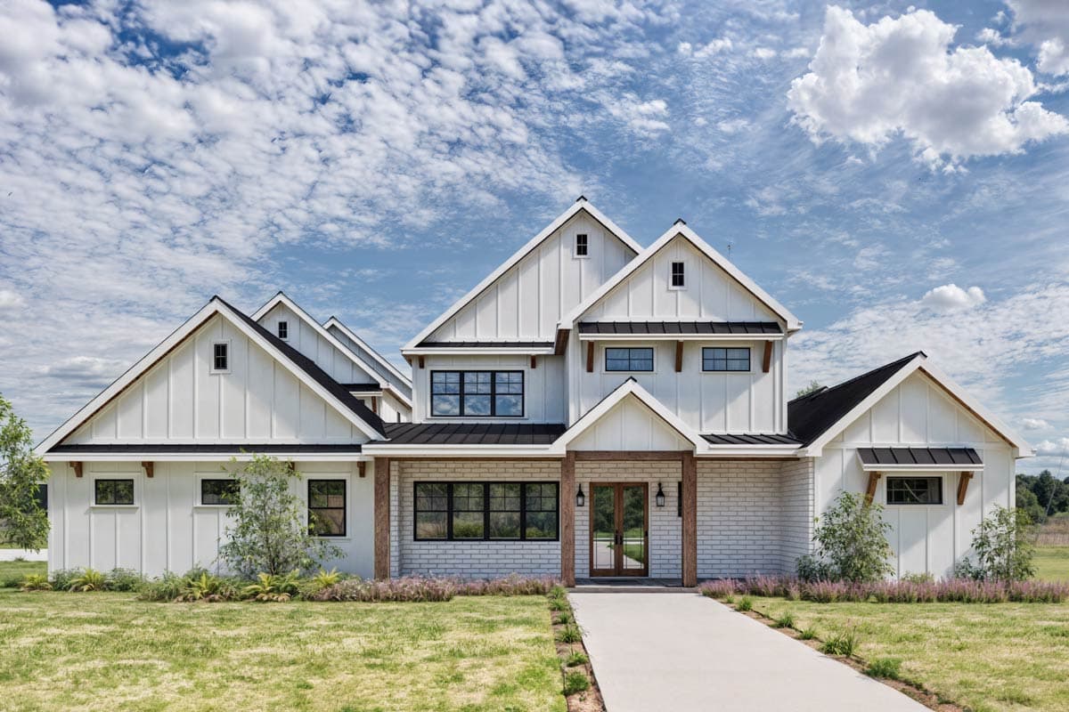 Modern Farmhouse house plan exterior with white vertical siding, gabled dormers, brick base, and wood posts at entry.