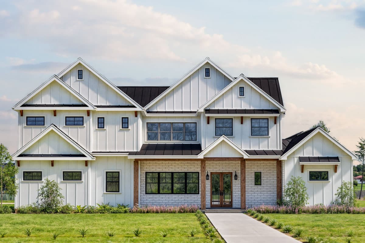 House plan exterior. Two-story Modern Farmhouse with gables, a covered porch, and a dark metal roof. White siding and black windows.