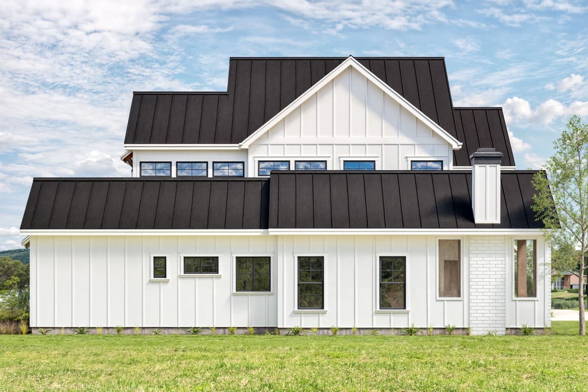 Modern Farmhouse house plan exterior with board and batten siding, dark standing seam metal roof, gable, and chimney.