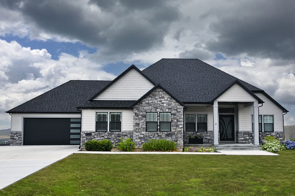 House plan exterior. Modern style, single story, with gabled roof, stone facade, and attached garage. Includes a covered front porch.