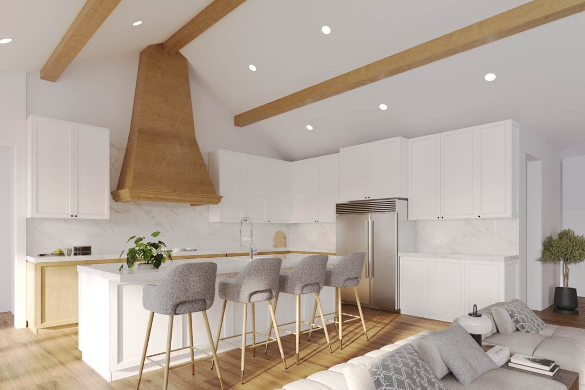 Kitchen and living area with vaulted ceiling, exposed wood beams, central island, and white cabinetry.