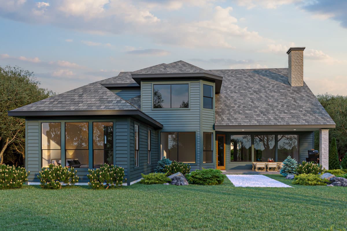 House plan exterior: Two-story home with multiple gables, large windows, a stone chimney, and a covered patio.