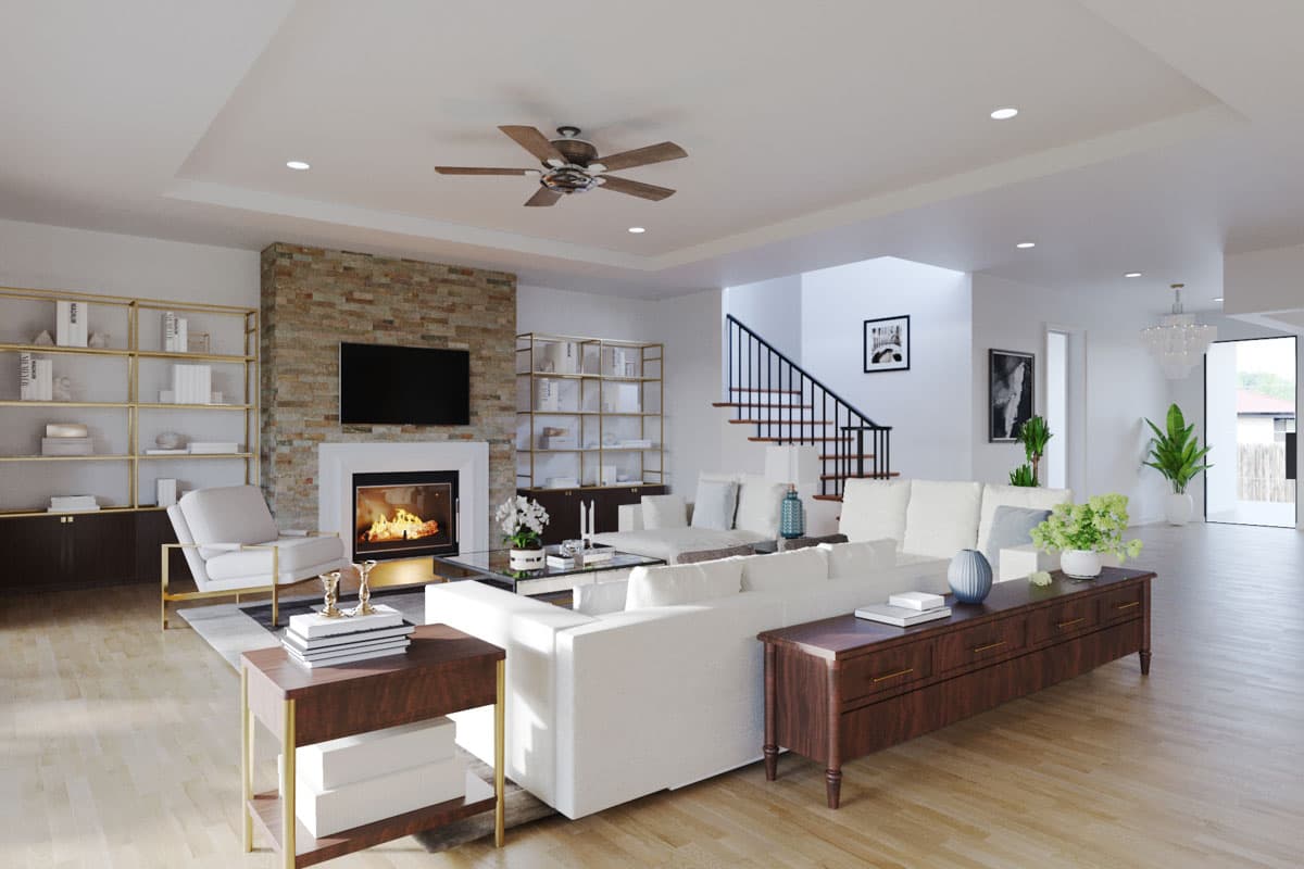 Open concept living area with fireplace, built-in shelving, ceiling fan, and staircase.