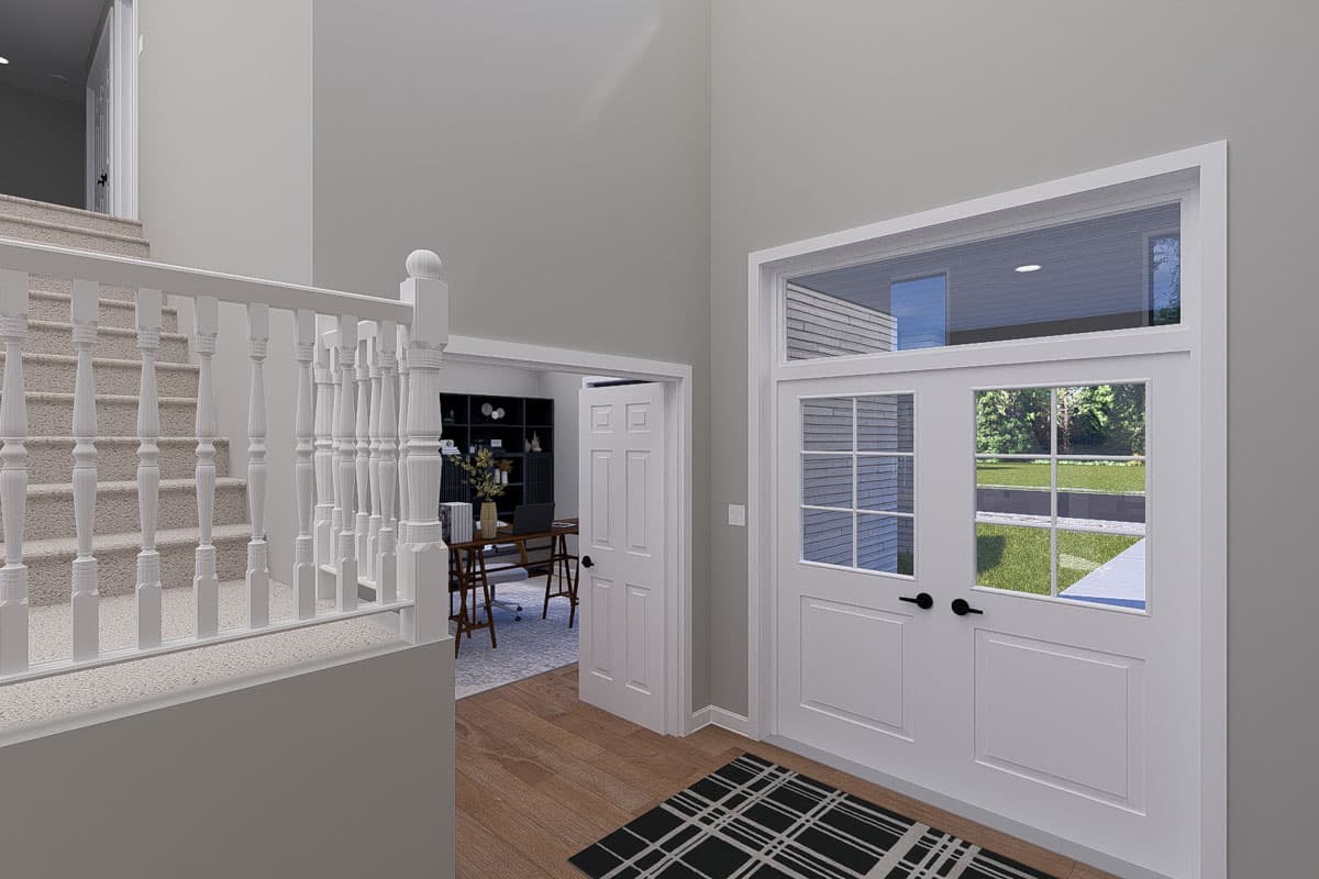 Interior view of a house entryway with a staircase, double doors, and a view into a home office.