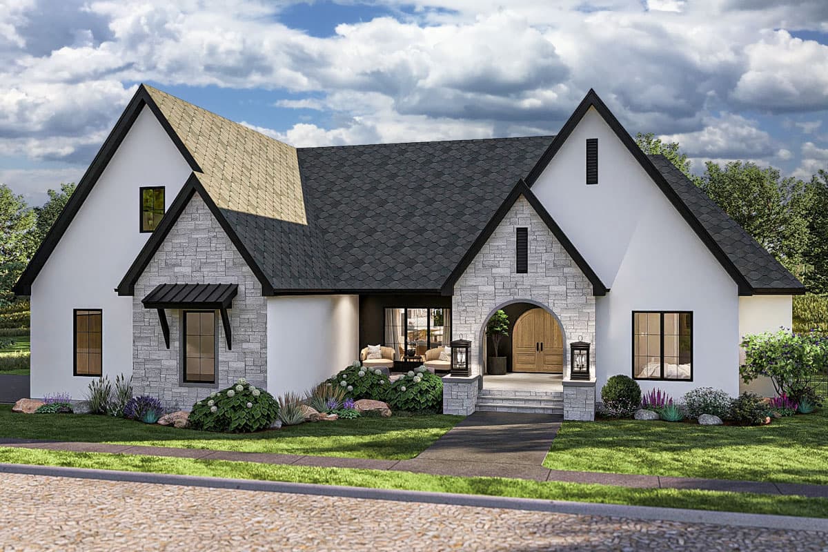 House plan exterior. Two-story home in a Tudor style with stone accents, a gabled roof, and an arched entry. Features a porch with lanterns.