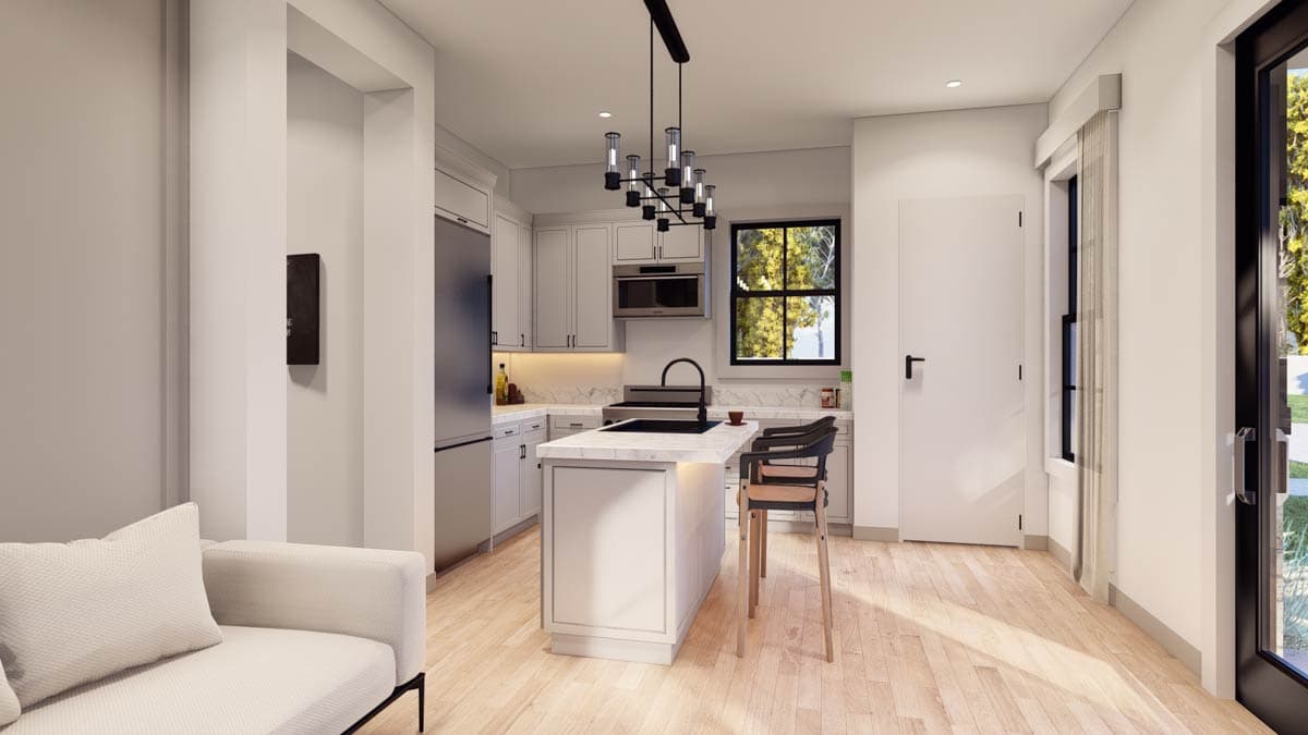 Kitchen with light gray cabinets, a central island with marble countertop, and a black pendant light fixture. Natural light from a window.