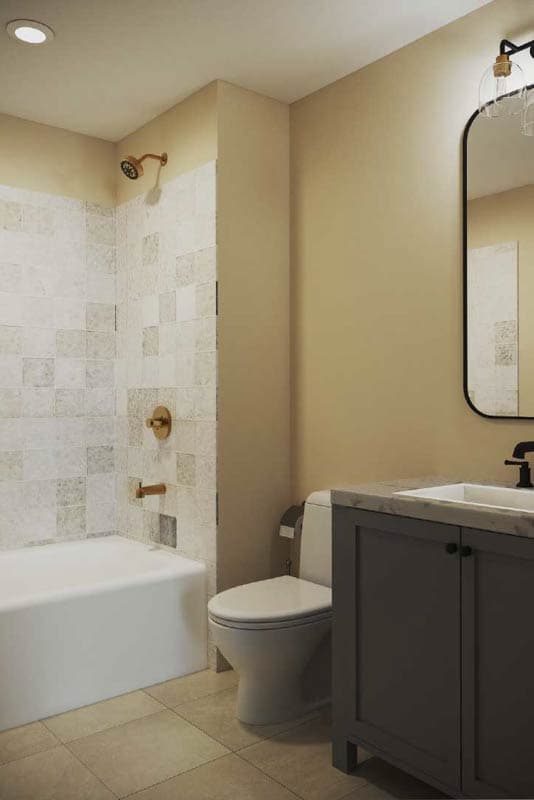 Bathroom interior with a bathtub, tiled shower walls, toilet, and vanity with a large mirror.