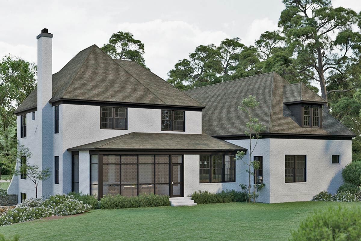 House plan exterior: Two-story brick home with gables, dormer, sunroom addition, and prominent chimney.