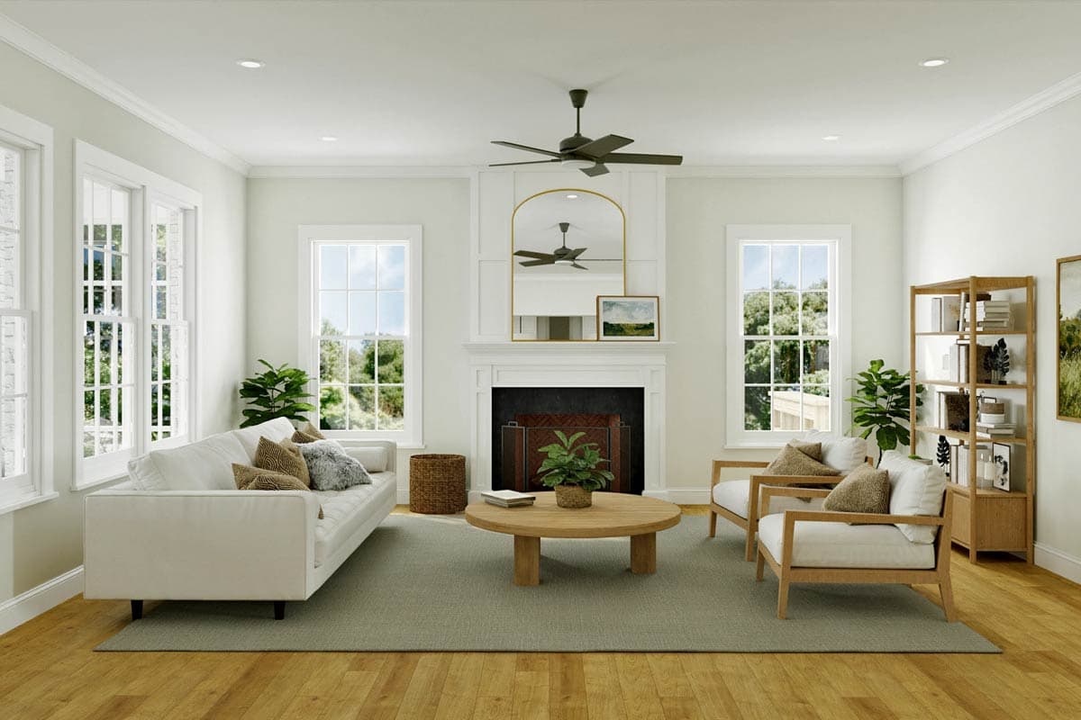 Living room with fireplace, large windows, sofa, chairs, coffee table, and bookshelf.